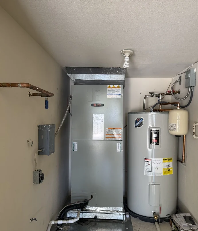 Installed central HVAC air handler beside a water heater