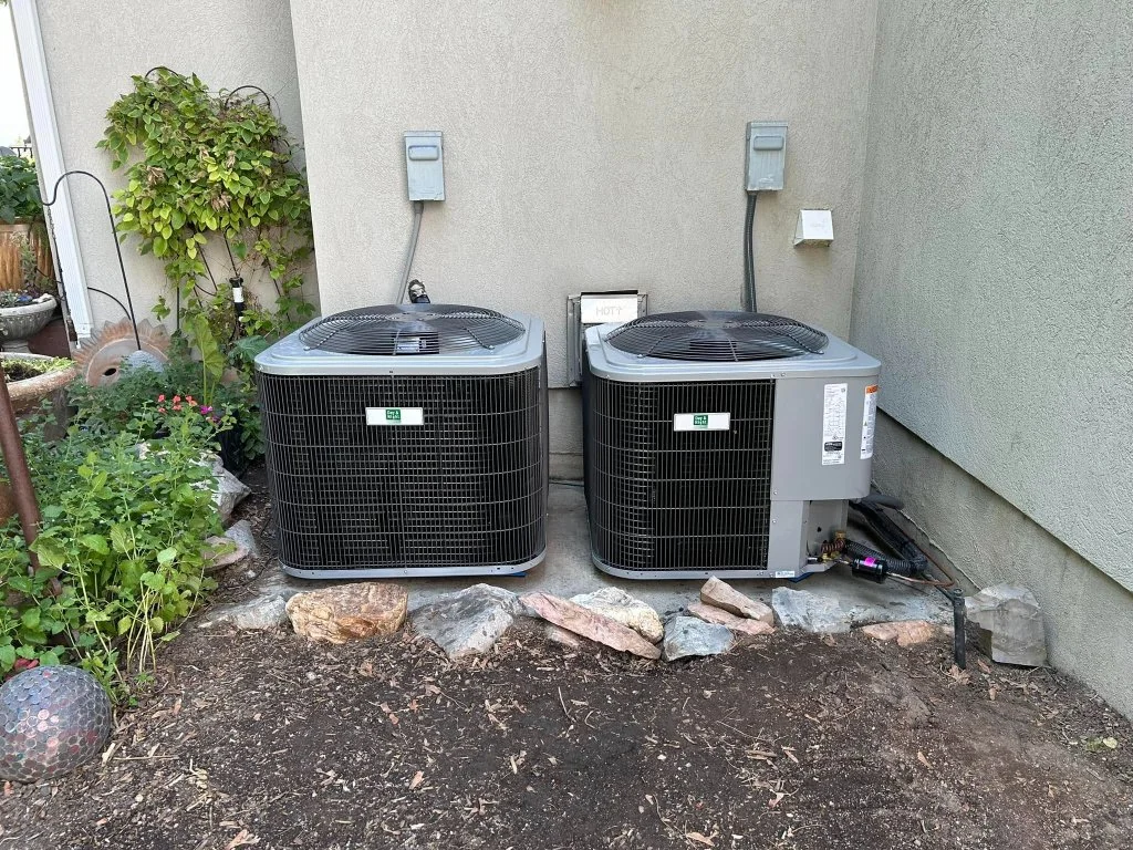 Two installed outdoor central air conditioning condensers