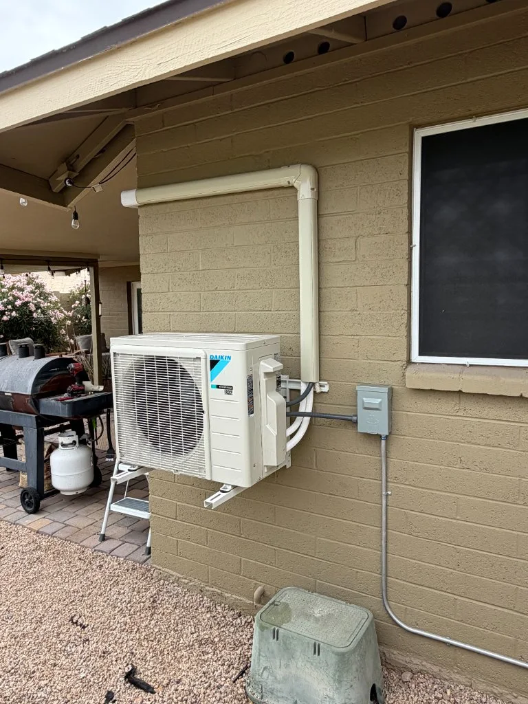 Outdoor mini-split condenser with refrigerant line routing