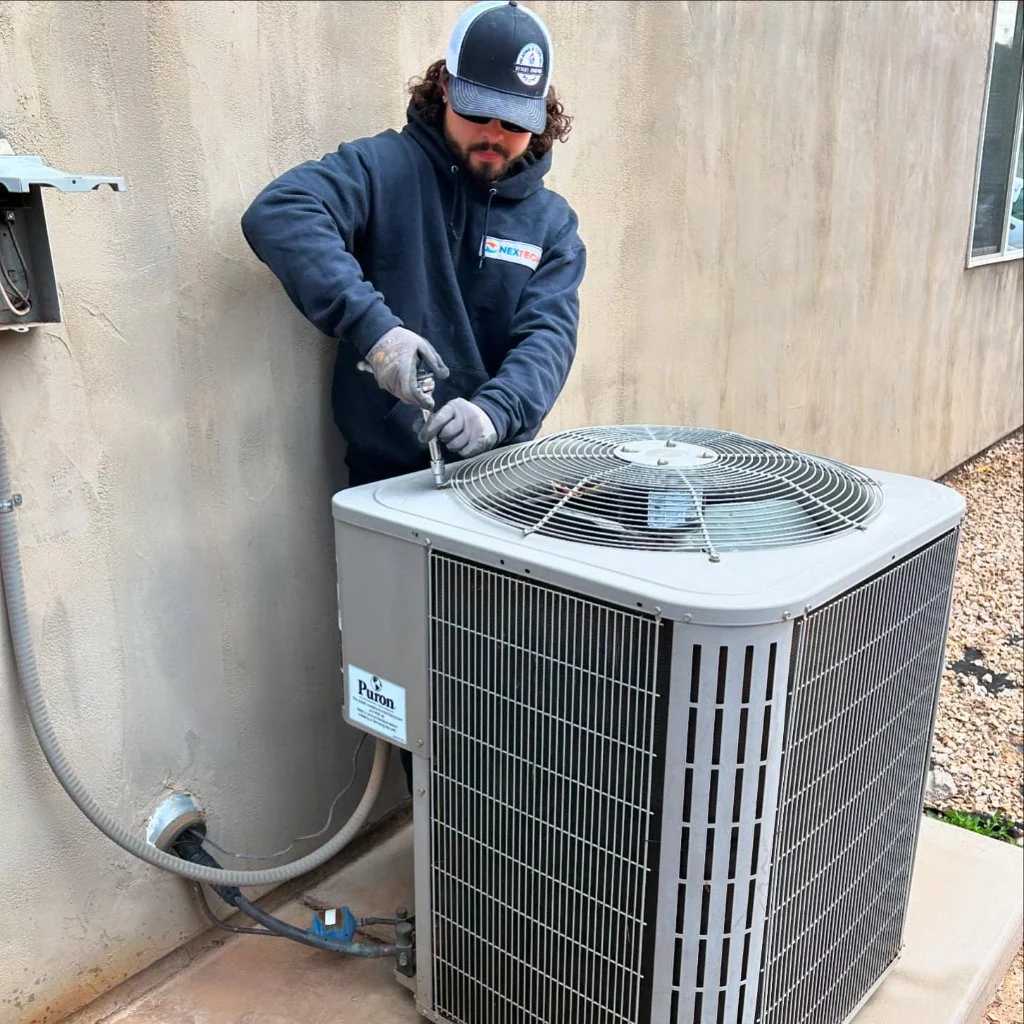 Technician servicing an outdoor central air conditioner